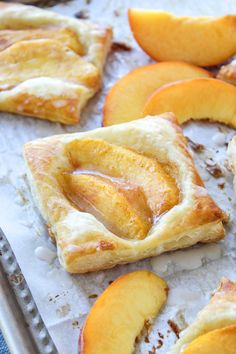 peach pies on a baking sheet ready to be baked in the oven with fresh peaches