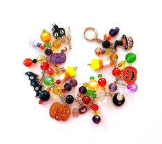 This happy and colorful Halloween charm bracelet is handcrafted by myself and a one of a kind original.  The gold plated chain is 8 inches long with 24 drops containing jack o lanterns, a  ghost, candy corn, cat, bat, spider, moon  and lots and lots of crystals so it sparkles as you move.  It contains an assortment of enamel charms, glass, acrylic and crystals.  If you need it shorter or longer just let me know, and I will adjust it to as close as possible to the size you desire. If you would li Handmade Multicolor Bracelets For Halloween, Multicolor Novelty Bracelets For Halloween, Handmade Multicolor Novelty Jewelry, Handmade Halloween Novelty Bracelets, Handmade Themed Halloween Bracelet, Handmade Themed Bracelet For Halloween, Fun Multicolor Halloween Jewelry, Handmade Themed Multicolor Jewelry, Handmade Multicolor Themed Jewelry