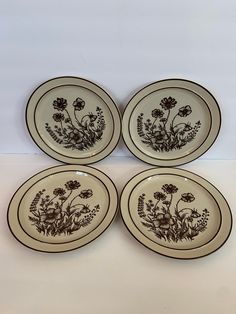 four brown and white plates with flowers on them