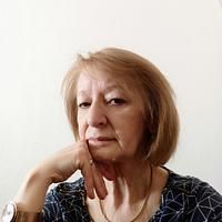 an older woman sitting at a table with her hand on her chin and looking off to the side