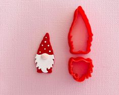 two cookie cutters, one with a gnome face and the other with a red hat