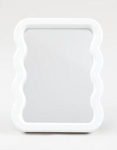 a white square shaped mirror with scalloped edges