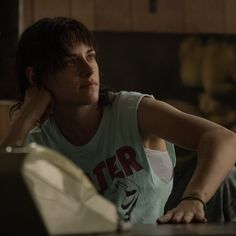 a woman sitting at a table with her hand on her head and looking off to the side