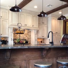 a kitchen with an island and stools next to the counter top in front of it