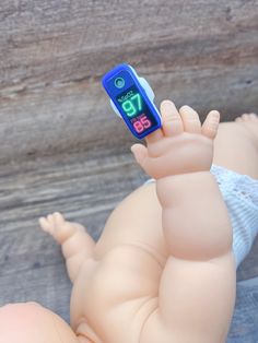 a baby doll with a cell phone in it's hand