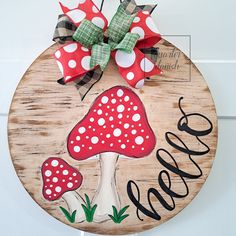 a wooden sign with red and white mushrooms on it