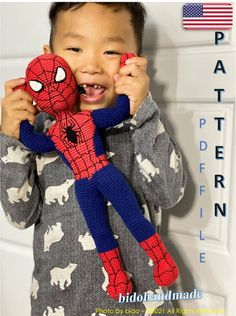 a young boy holding a stuffed spiderman toy in front of his face and smiling at the camera