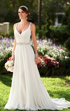 a woman in a wedding dress standing on the grass