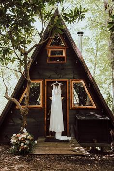 a wedding dress hanging in front of a cabin