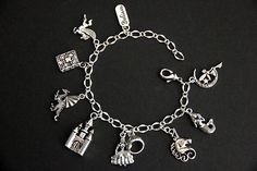 "A collection of silver plated fairy tale themed charms have been dispersed around a shimmering silver plated bracelet chain in this handmade charm bracelet. This fantasy storybook charm bracelet is then completed with a lobster clasp and a 1/2 inch of chain at the end for adjustable sizing. Charms in this bracelet include a \"Believe\" tab charm, pegasus charm, storybook charm, dragon charm, castle charm, princess charm with crown charm, unicorn charm, mermaid charm, and a fairy on the moon cha Princess Style Silver Jewelry Gift, Themed Silver Charm Bracelet, Adjustable Silver Fantasy Bracelet, Whimsical Silver Dangling Charms, Fantasy Style Silver Bracelet, Silver Fantasy Bracelet, Themed Silver Bracelets With Charms, Whimsical Silver Charms For Gifts, Whimsical Silver Bracelet Jewelry