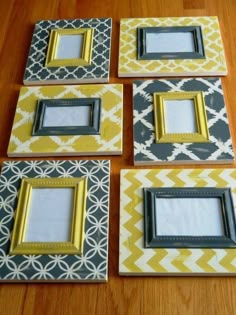 four yellow and gray frames sitting on top of a wooden table