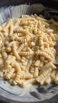 macaroni and cheese is being stirred in a bowl