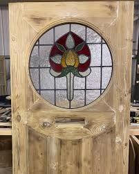 a wooden door with a stained glass flower in the center and side panels on it