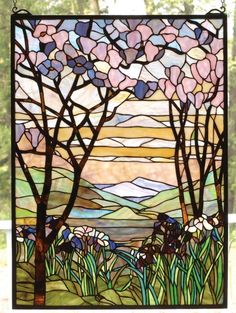 a stained glass window with trees and flowers