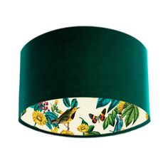 a green lampshade with birds and flowers on the bottom, against a white background