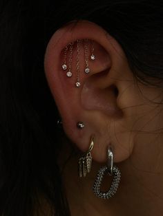 a woman's ear with three different piercings attached to the side of her ear