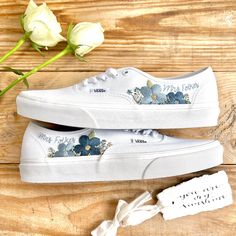 Fresh all white Vans Authentic trainers delicately hand embroidered with bold, bright flowers and finished with a name, date, initials or words of your choice. This design can be embroidered in any colour scheme you choose, please leave a note during checkout with any specific requests. Each pair is hand made to order and stitched with high quality embroidery thread which is washable and fade resistant.  If you're looking for something a little more bespoke, I offer a limited number of fully custom hand embroidered trainers tailored to your wishes. Consider your wedding theme, your favourite flowers, your bouquet and more all tailored to your budget. We can work together to create something perfect for you. Check out my Etsy store for the 'custom order' listing, please read item descriptio White Cotton Sneakers With Floral Embroidery, White Low-top Sneakers With Floral Embroidery, White Floral Embroidery Low-top Sneakers, White Floral Embroidered Low-top Sneakers, White Casual Sneakers For Wedding, White Casual Wedding Sneakers, White Vans Authentic, All White Vans, Wedding Vans