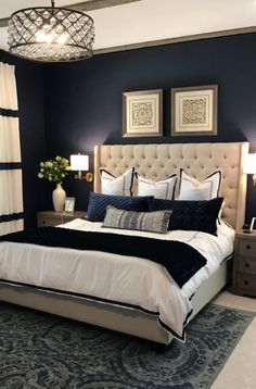 a bedroom with blue walls, white bedding and black accents on the headboard