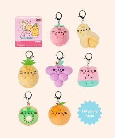 a set of six key chains with different designs on them, including an apple, pineapple, and cat