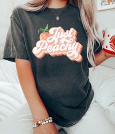 Trendy Peach T-shirt With Letter Print, Trendy Peach Top With Graphic Print, Peach Crew Neck Top With Graphic Print, Heather Peach Letter Print Top For Spring, Trendy Heather Peach Top With Graphic Print, Casual Peach Tops With Letter Print, Cute Peach T-shirt With Graphic Print, Heather Peach Letter Print Crew Neck Top, Trendy Relaxed Fit Peach Tops