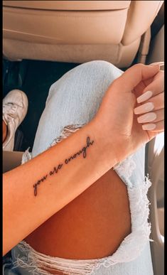 a woman's arm with the words you are enough written in cursive font