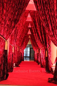 a red carpeted hallway with drapes on the sides and curtains at the end