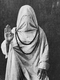 an old photo of a person wearing a veil and holding their hands up in the air