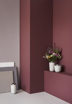 a vase with flowers sitting on top of a shelf