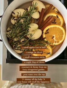 a bowl filled with orange slices, cinnamon sticks and rosemary next to an oven mitt