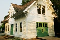 a white house with green doors and windows