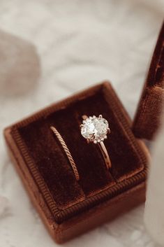 an engagement ring sits in a velvet box