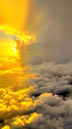 the sun is shining brightly through clouds in this photo taken from an airplane window on a cloudy day