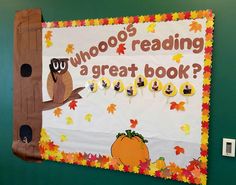 a bulletin board with an owl reading a great book written on it and fall leaves