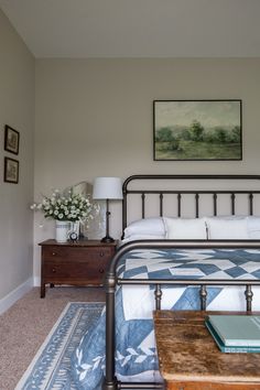 a bedroom with a metal bed frame and blue bedspread on top of it