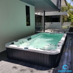 a large hot tub sitting on top of a wooden floor next to a white wall