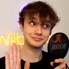 a young man holding up a mirror to show the word ride on it's face