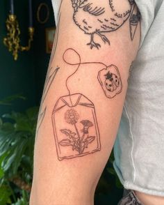 a tattoo on the arm of a person with a bird and flower in it's vase