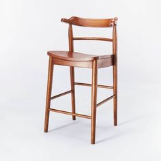 a wooden chair with a bent back and arm rests against a white background in the foreground