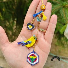 someone is holding some colorful beaded keychains in their hand and it looks like they are from the video game super mario