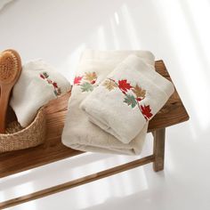 a wooden bench with towels and a brush on top of it next to a basket