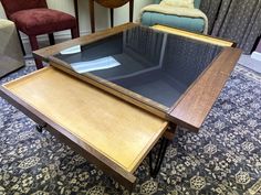 two tables with glass top sitting on a carpeted floor