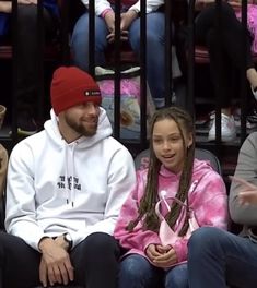 two people sitting next to each other at a basketball game