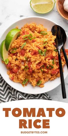 a white plate topped with rice next to a lime wedge and a fork on top of a table