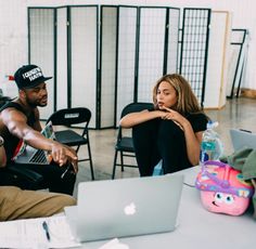 two people sitting at a table with laptops