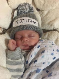 a newborn baby wearing a knitted hat and sleeping