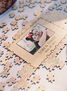 a couple's wedding photo surrounded by puzzles on a table with other items