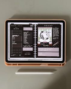 an electronic device is sitting on top of a table next to a pen and paper