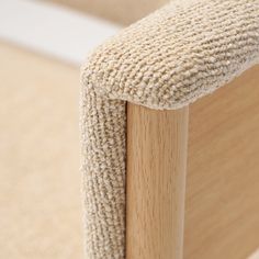 a close up view of the back end of a chair with a wooden armrest