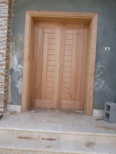 two wooden doors sitting on the side of a building