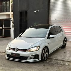 a white car parked in front of a building